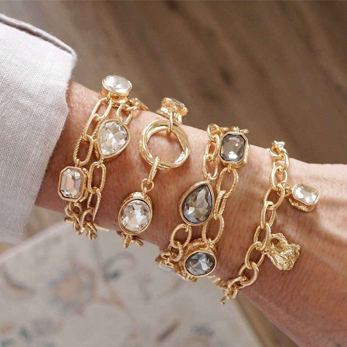 Brilliant Bond – Statement Chain Bracelets with Reflective Crystals: 4 golden charms and 1 Radiant cut Crystal